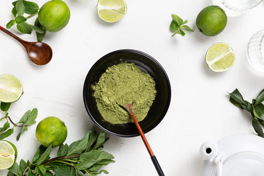 Organic moringa powder with fresh limes on white background